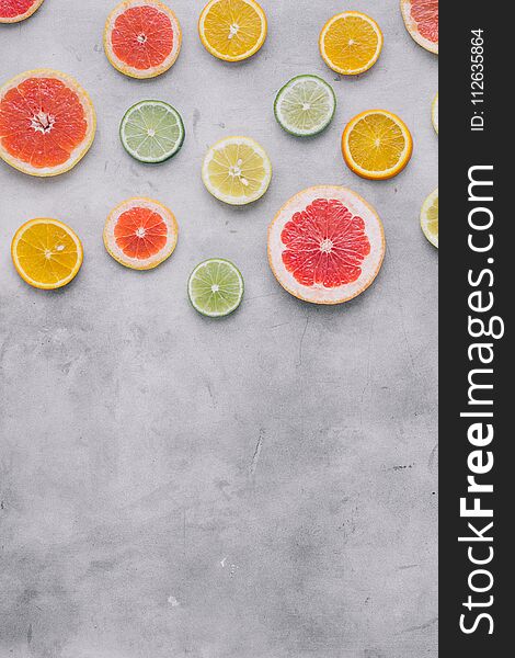 Top view sliced citrus fruit on light background with border. Flat lay. Summer background. Top view sliced citrus fruit on light background with border. Flat lay. Summer background