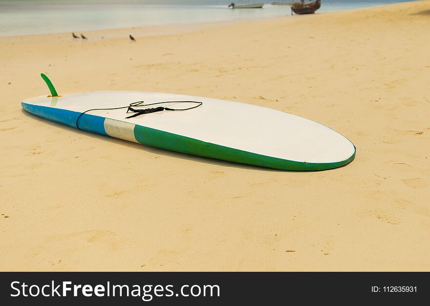 Surfboard in the sand at the beach. Summer background. Surfboard in the sand at the beach. Summer background