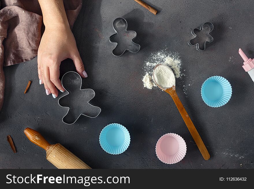 Bakery background. chef`s hand, spoon with flour, bakeware and rolling pin on dark background top view. Bakery background. chef`s hand, spoon with flour, bakeware and rolling pin on dark background top view