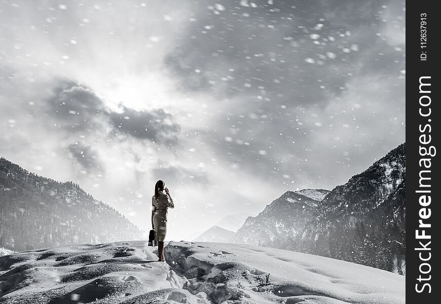 Elegant businesswoman among snowy mountains talking mobile phone. Elegant businesswoman among snowy mountains talking mobile phone