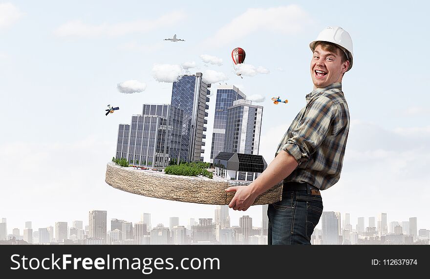 Man engineer in helmet with mini exterior model in hands. Mixed media. Man engineer in helmet with mini exterior model in hands. Mixed media