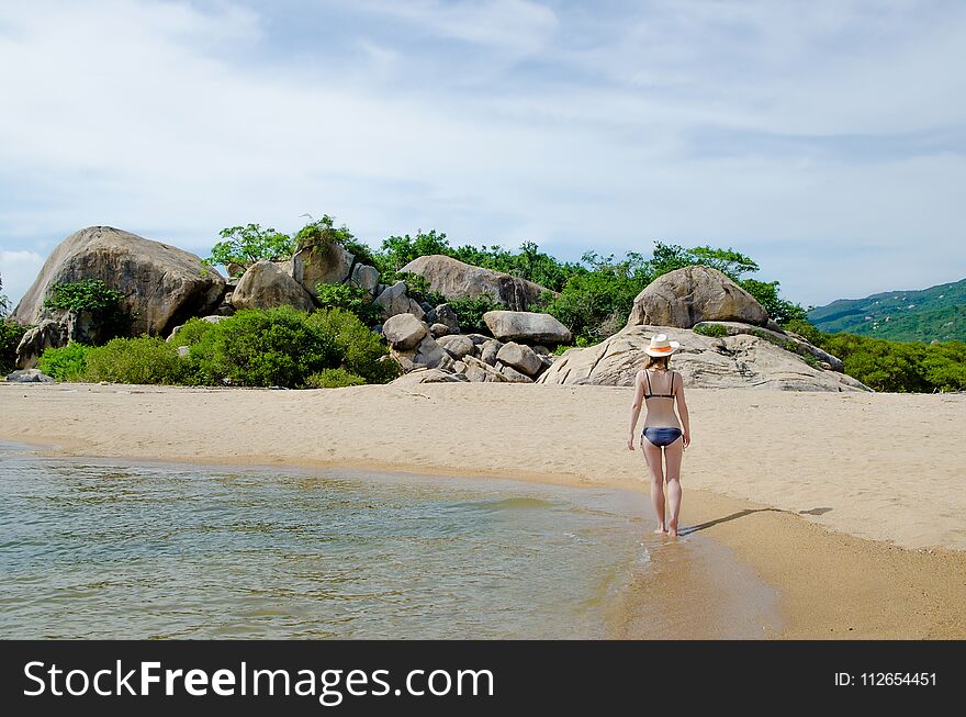 Blonde in a bikini on a paradise beach.