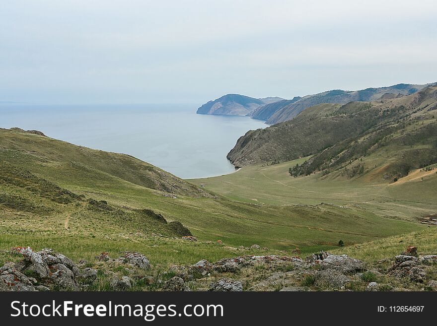 Lake Baikal, beautiful blue water and sky and green hills, Russia. Lake Baikal, beautiful blue water and sky and green hills, Russia.