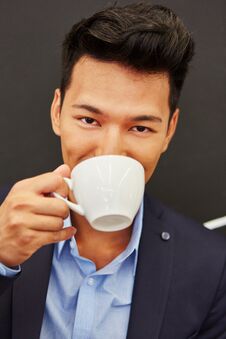 Asian Man Enjoys Break And Drinks Coffee Stock Images