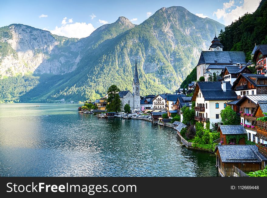 Houses Beside Body of Water and Mountains at Daytime
