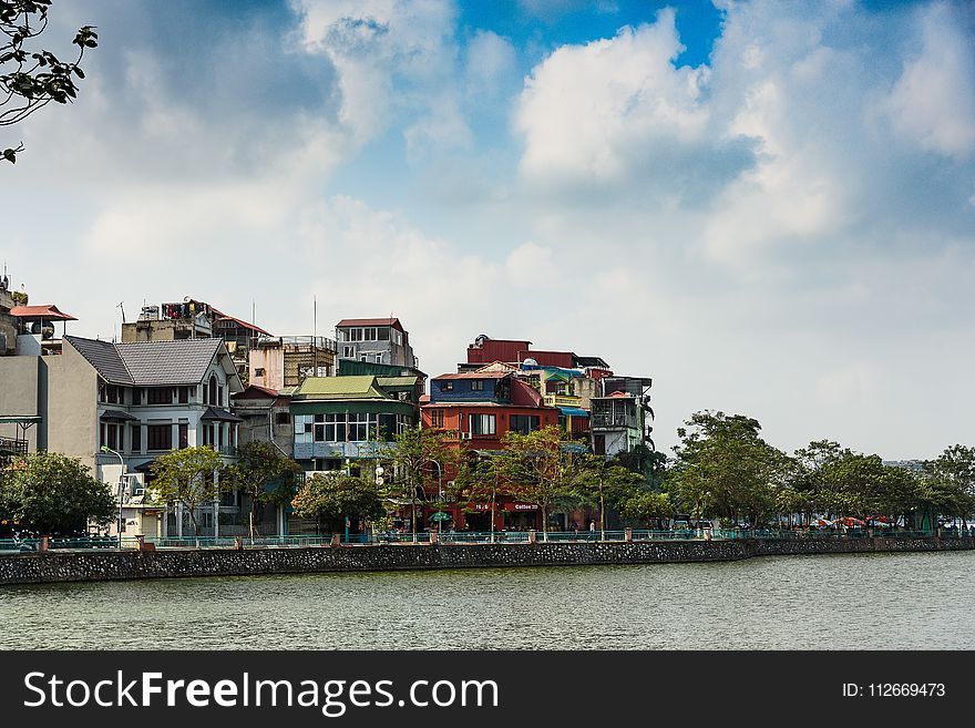 Assorted-color Buildings Near Water And Trees