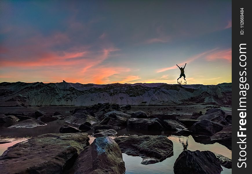 Person Jumping on Mountain Photo