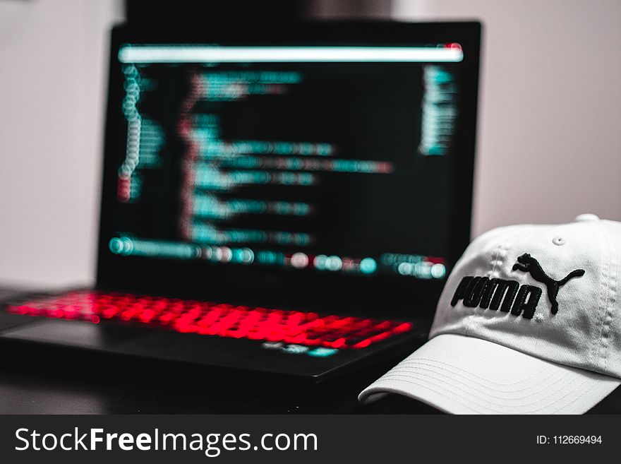 Black And Red Laptop Computer Beside White Puma Curve Brim Cap