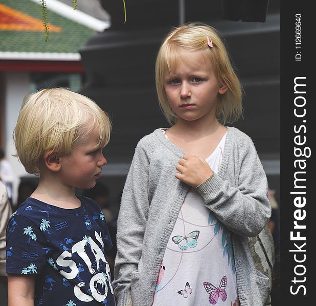 Boy Wearing Blue and White Stay Cool Print Crew-neck T-shirt Next to Girl Wearing White and Teal Butterfly Printed Scoop-neck Shirt and Gray Open Long-sleeved Cardigan