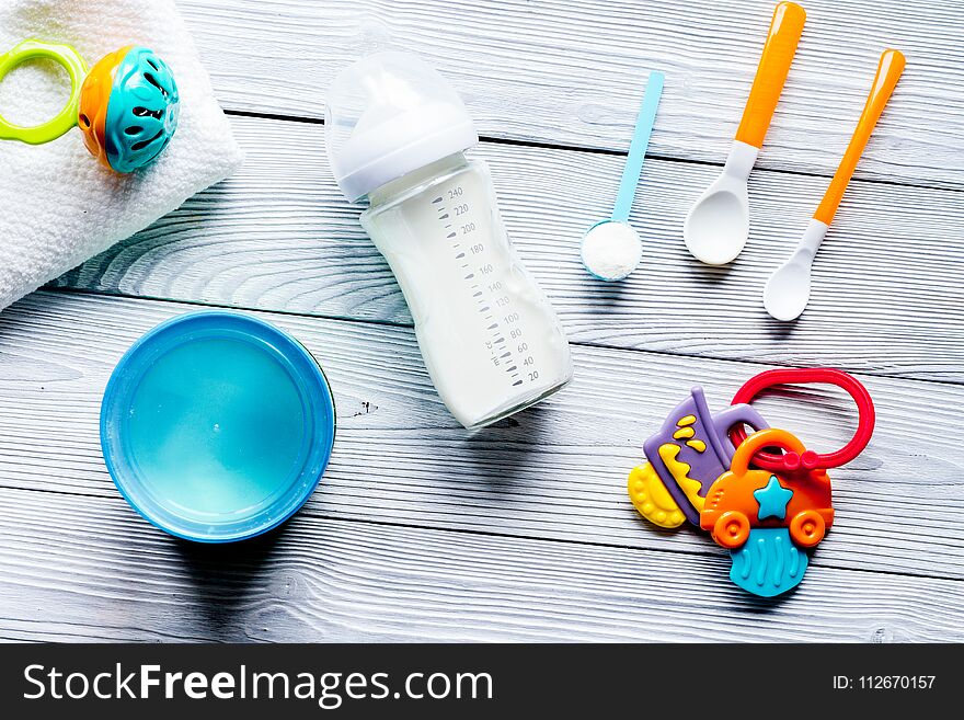 Preparation of mixture baby feeding on wooden background top view.