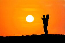 Silhouette Of A Mother Carrying Her Son Watching The Sunset Stock Photos