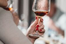 Woman Holds Glass Of Red Wine. People Consider The Color Of The Wine And Try How It Smells In Different Glasses Stock Photos