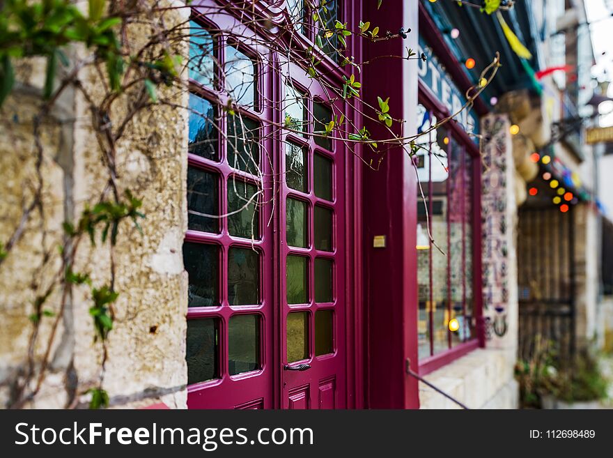 Old beautiful violet wooden door with glass in modern-style, Noyers, France