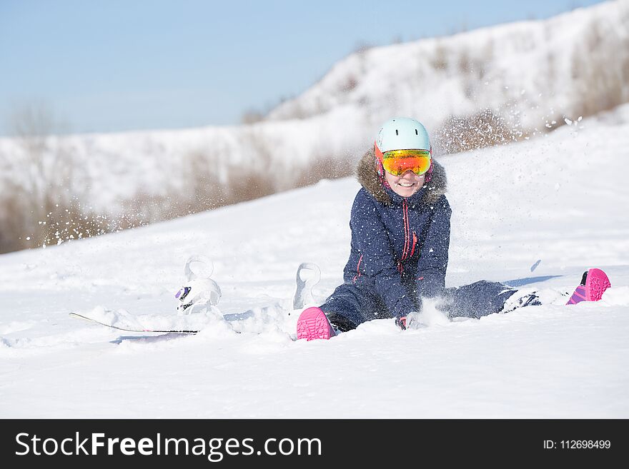 Picture of athlete woman in helmet sitting at snowdrift