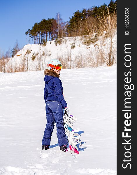 Photo from back of sports woman standing with snowboard