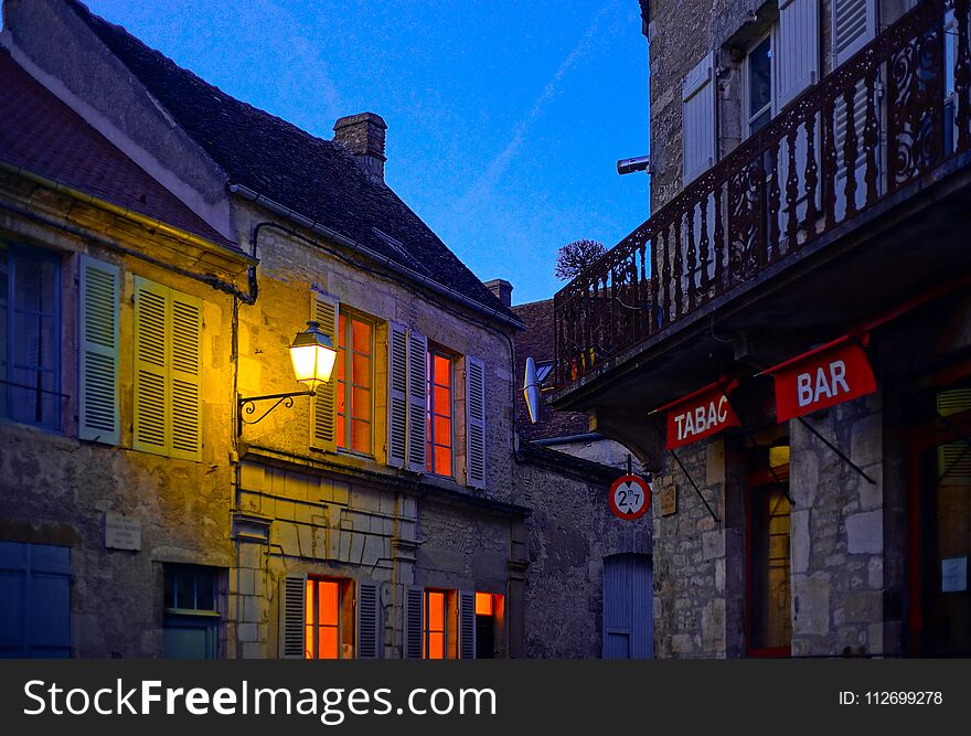 Evening time in old french city Vezelay. Light of old-styled street lantern.. France.