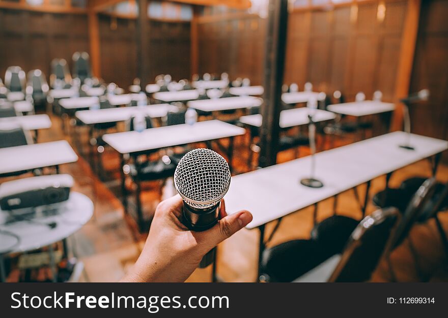 Close-up Microphone With Blurred People Attending Seminar Background. Vintage Process.