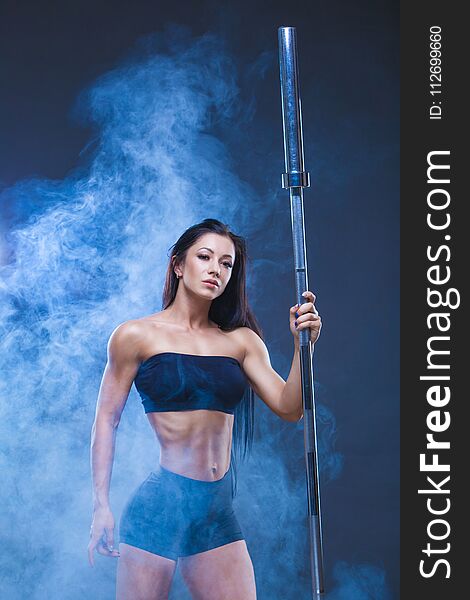 Brutal athletic woman holds a barbell. The concept of exercise sports, advertising a gym.Isolated on a black background