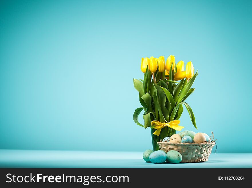 Yellow tulips and Easter eggs on blue background. Yellow tulips and Easter eggs on blue background