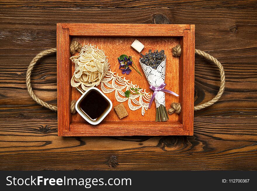 Cup of coffee on a red serving board. Lavender bouquet.