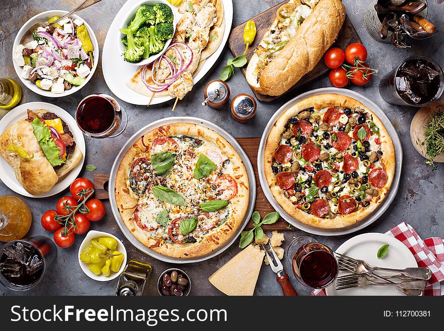 Big dinner with pizza, salad and sandwiches overhead view. Big dinner with pizza, salad and sandwiches overhead view