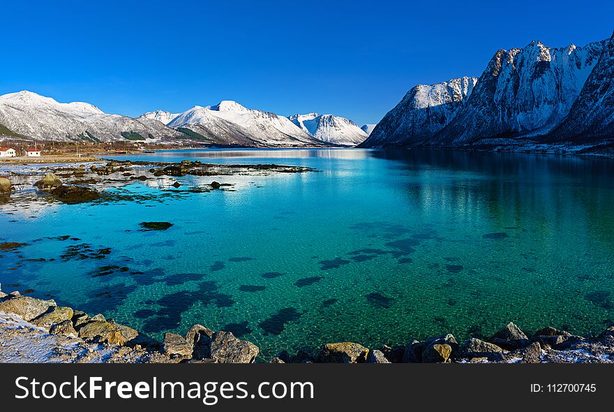 Panoramic view of beautiful winter lake with snowy mountains at Lofoten Islands in Northern Norway. Panoramic view of beautiful winter lake with snowy mountains at Lofoten Islands in Northern Norway