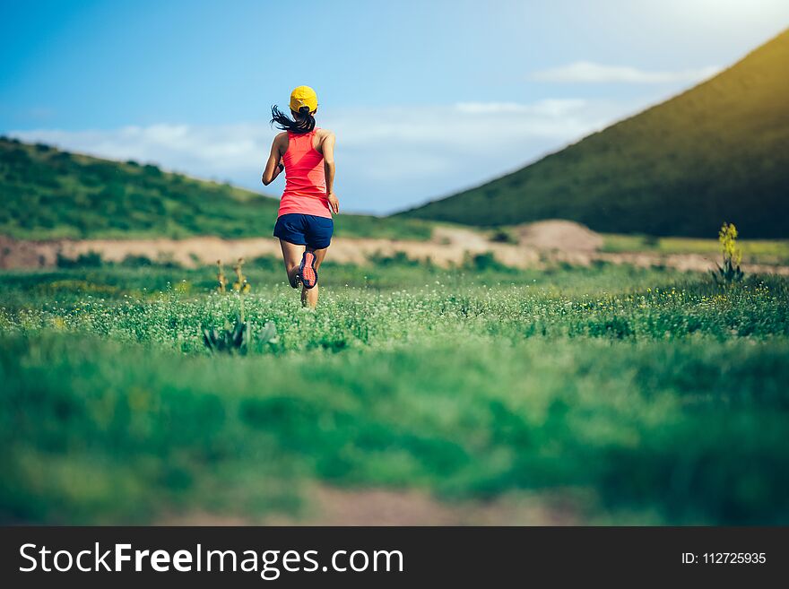 Woman trail runner running in mountains