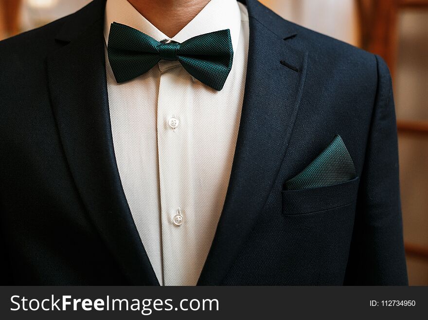 Groom black suit with a green bow tie. Groom black suit with a green bow tie