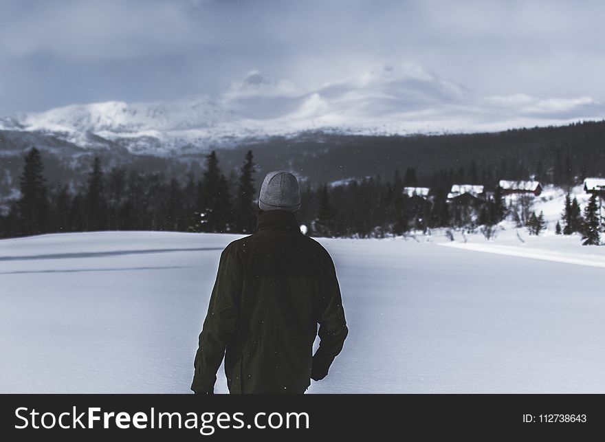 Man Wearing Black Jacket Walking in the Snow