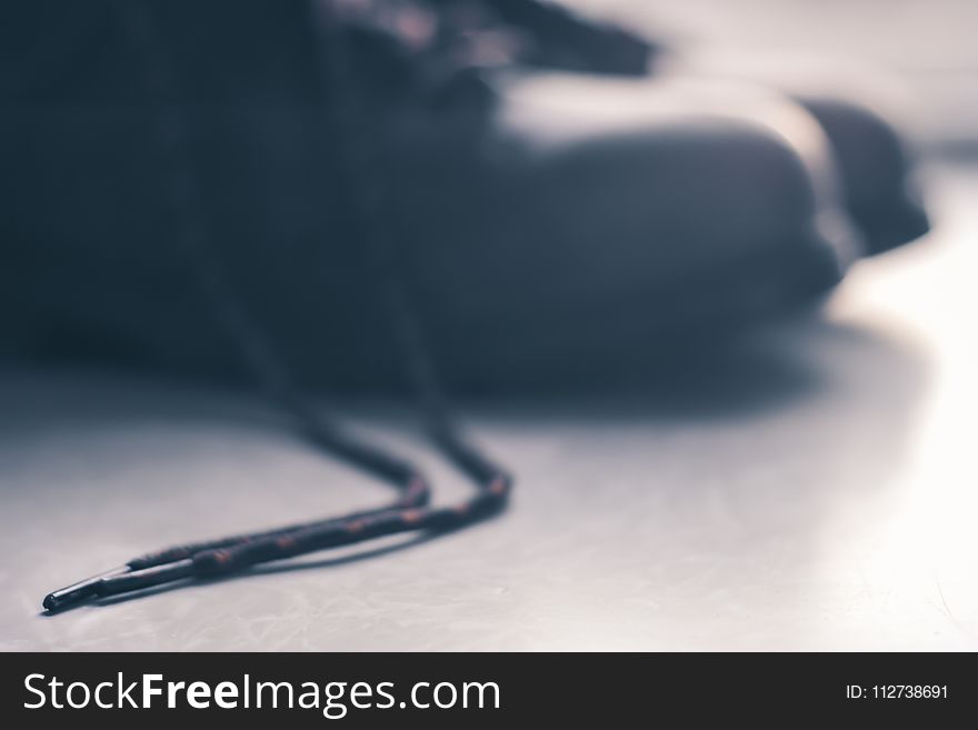 Black Shoelace Placed on Gray Floor