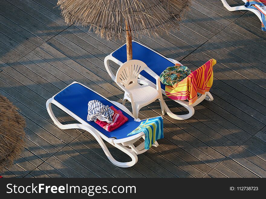 Loungers with towels to reserve them for private use. In hotel complex. Majorca, Palma Nova, Spain. Loungers with towels to reserve them for private use. In hotel complex. Majorca, Palma Nova, Spain.