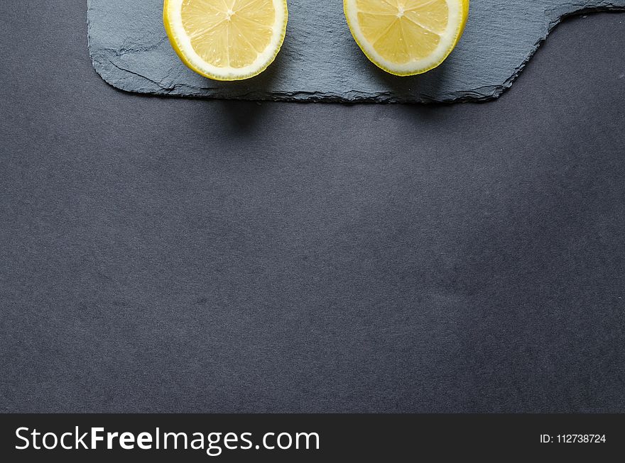 Two Sliced Lemons on Black Surface