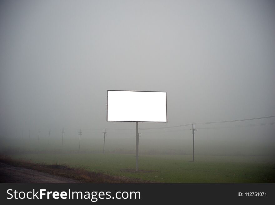 Isolated billboard template on a foggy road