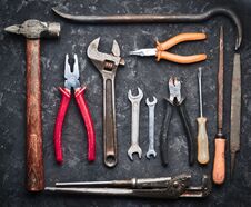 Many Working Tools On A Black Concrete Table. Nippers, File, Pliers, Scrap, Hammer, Wrench, Screwdriver. Top View. Flat Lay Royalty Free Stock Photo