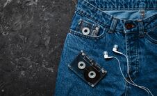 Jeans, Audio Cassette, Headphones Layout On A Black Concrete Table. Conceptual Photo Stock Photos Jeans, Audio Cassette, Headphones Layout On A Black Concrete Table. Conceptual Photo Stock Photos