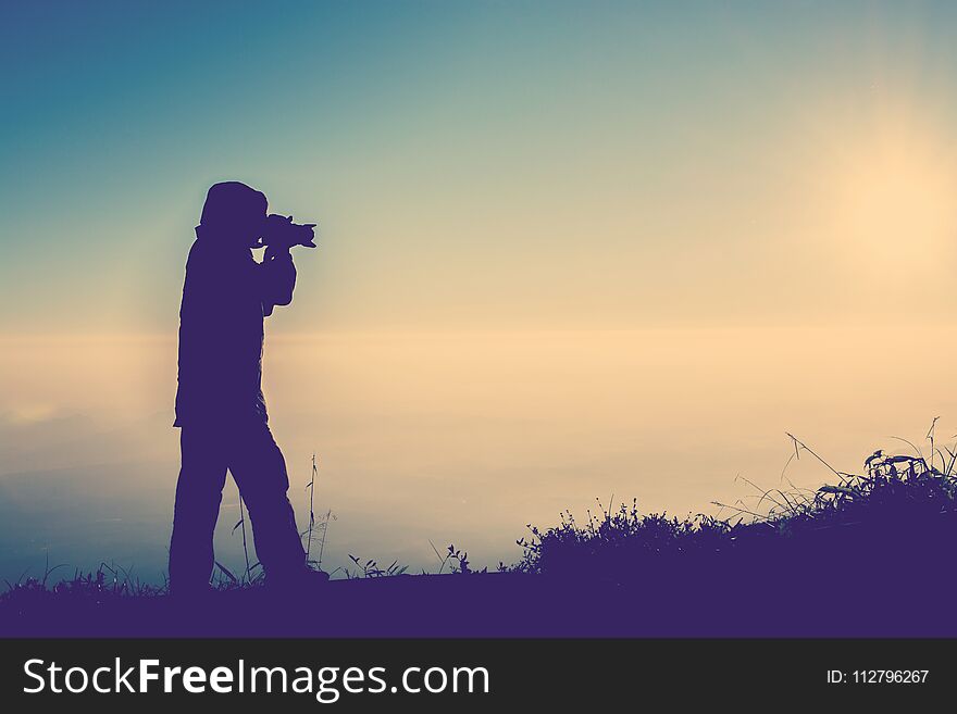 Silhouette of female photographer standing focus for take a photo