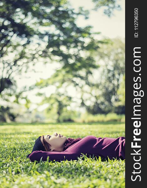 Beautiful young woman lying thinking something In the park