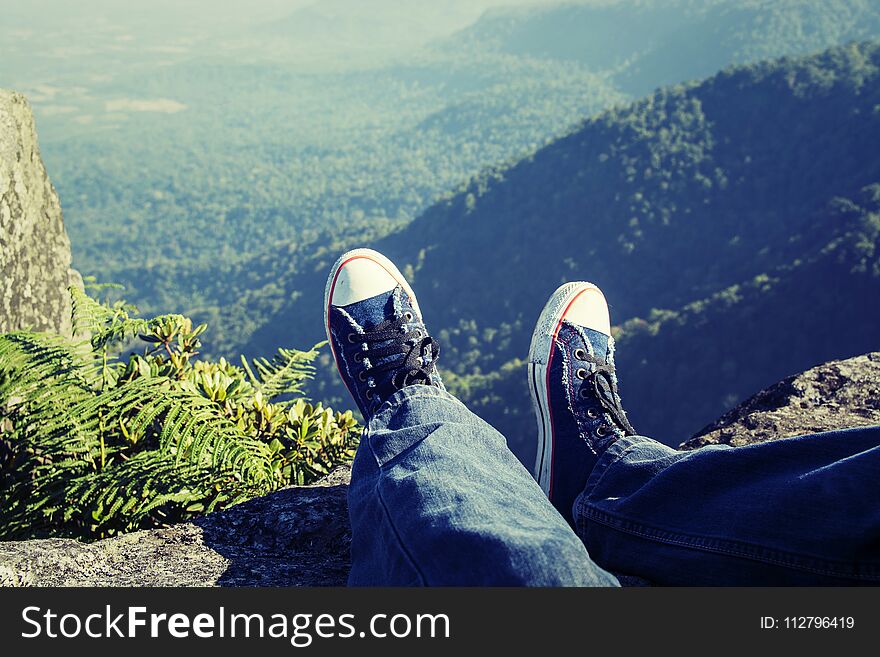 Man laying feet top of the mountain and View