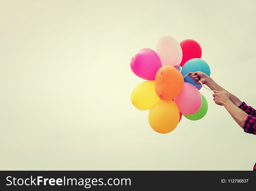 Hand Of A Teenage Girl Holding Colorful Balloons In The Sunshine