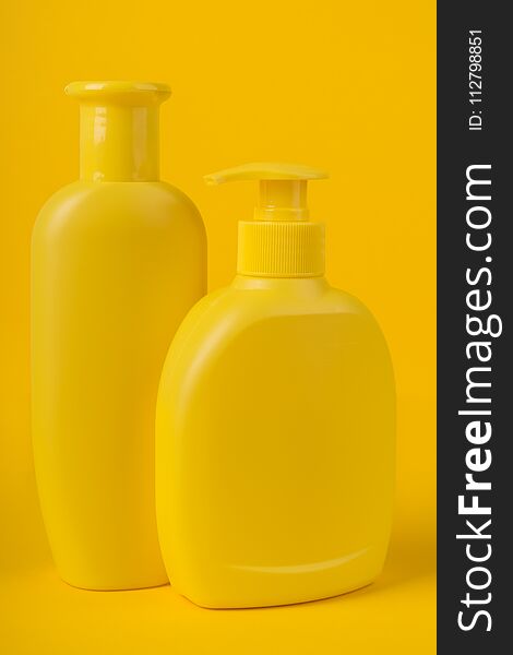 Group Cosmetic Bottles Isolated On Yellow Background.