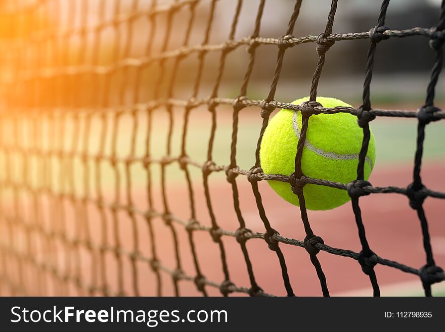Tennis ball hitting to net on blur court background