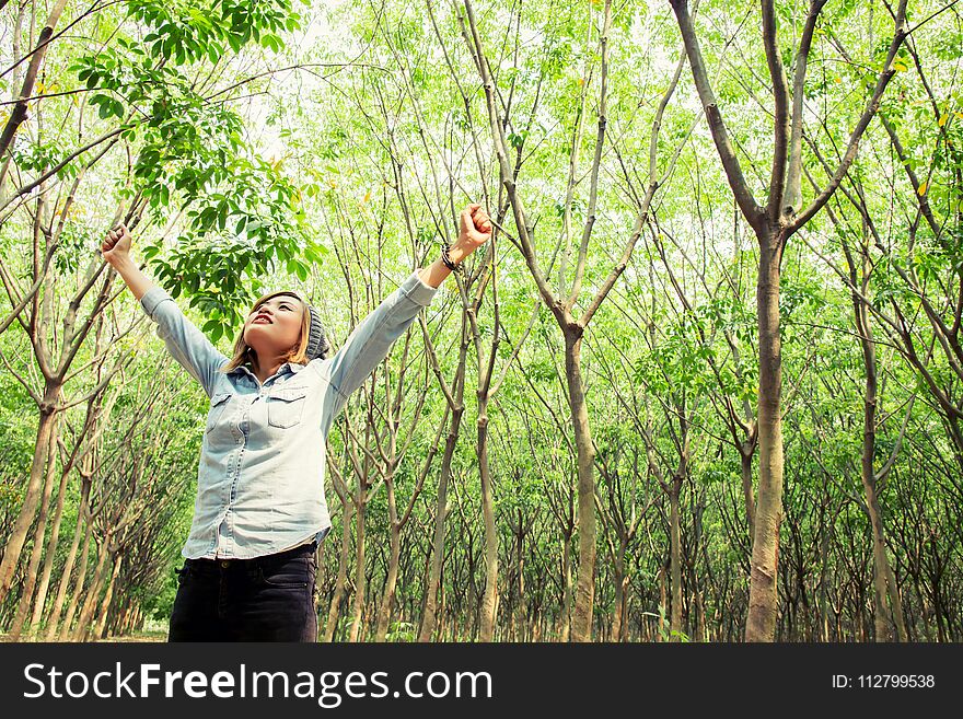 Beautiful young woman enjoying with nature in the forest background