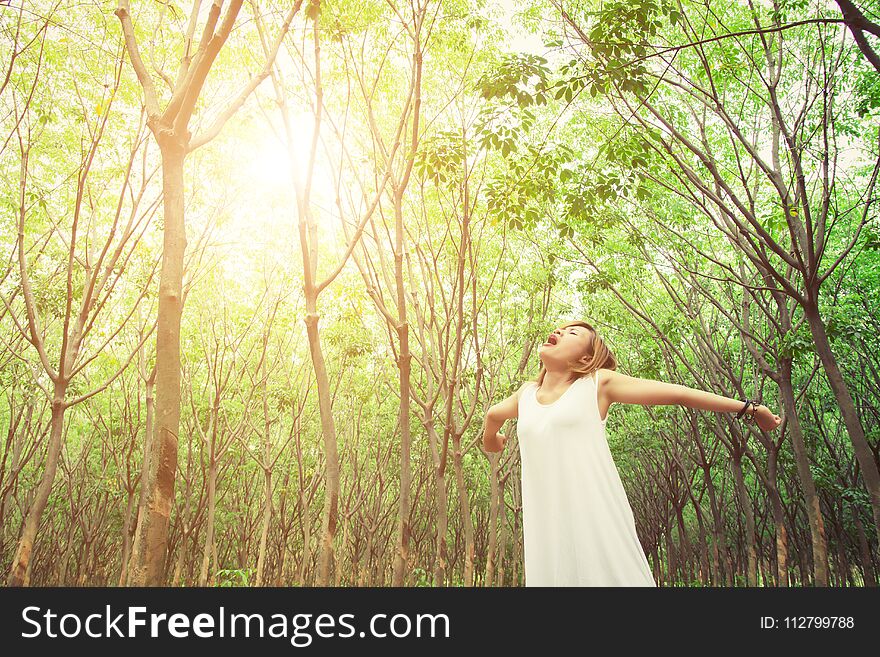 Women lifestyle concept : Beautiful young asian woman stretching and yawning with fresh air in the green forest