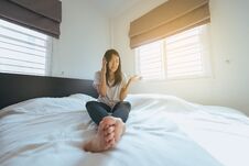 Asian Woman Talking With Her Mobilephone In Bedroom Feeling Serious Stock Photos