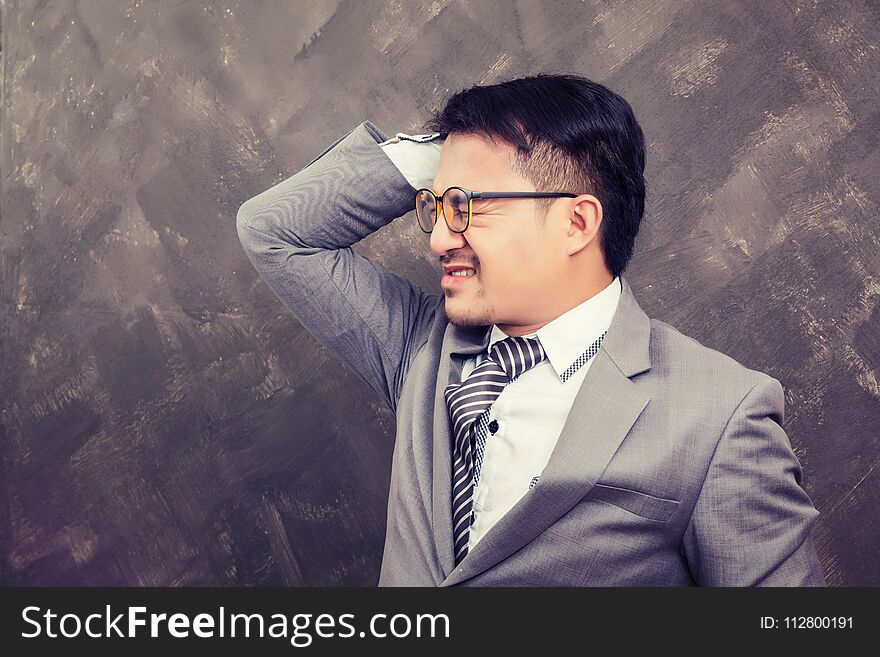 Young businessman holding hands on head so headache he got trouble with work