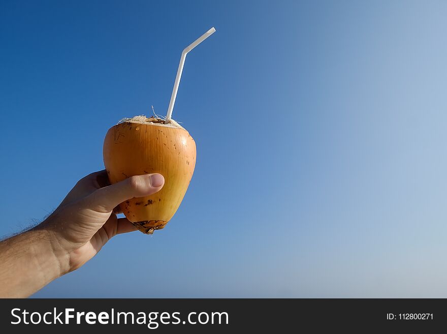 Man Holding A A Coconut On The Beach.