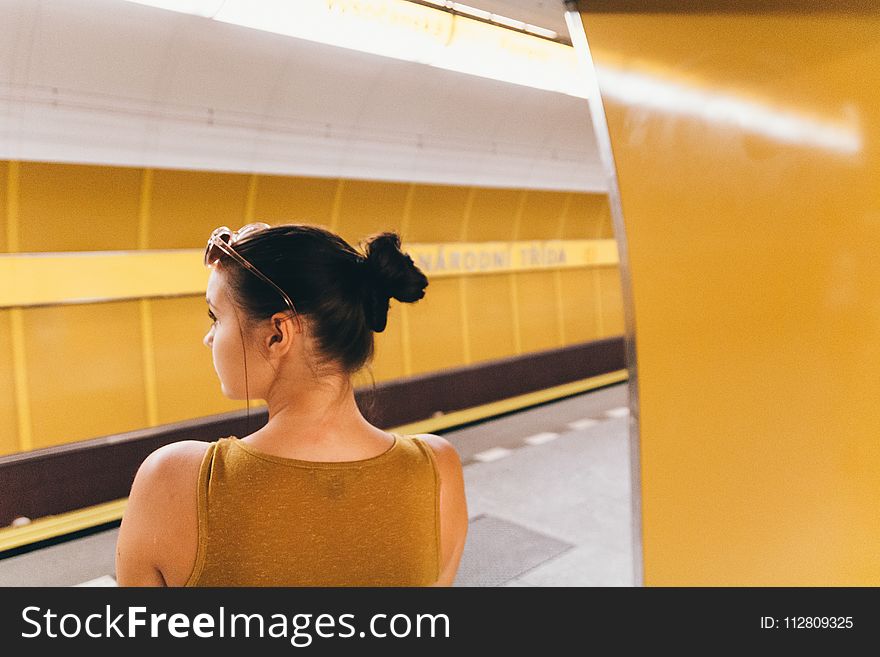 Woman Wearing Gold Sleeveless Top Inside the Building