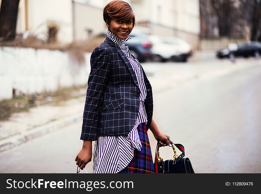 Photo of Woman in Black and Gray Blazer Holding Bag
