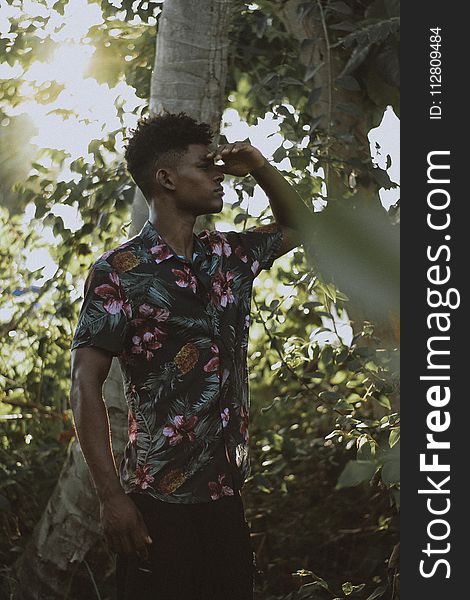 Man Wears Multicolored Floral Button-up Short-sleeved Shirt Beside Tree
