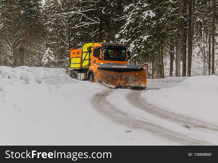 Yellow, Orange, and Black Truck Plowing Snow